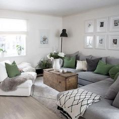 a living room filled with lots of grey and green furniture