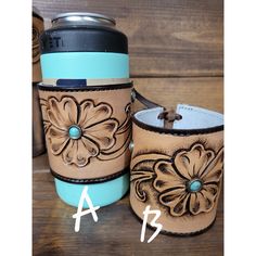 two leather cups with flowers on them and one has a blue cup in the middle