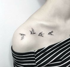 a woman's chest with three birds flying in the sky on her left side