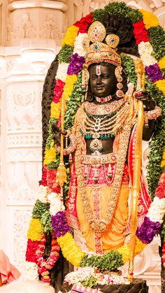 the statue is decorated with flowers and garlands