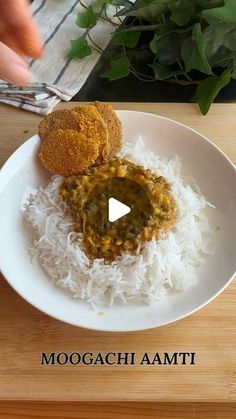 a white plate topped with rice and two pieces of bread on top of it next to a plant