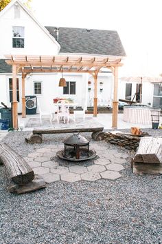 a fire pit surrounded by benches in front of a house