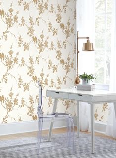 a white desk and chair in front of a wallpapered room with flowers on it