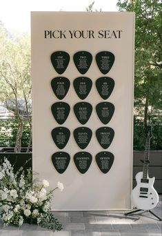 the pick your seat guitar picks are on display in front of a sign with flowers