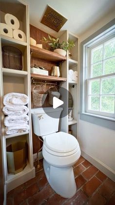 a white toilet sitting inside of a bathroom next to a shelf filled with rolls of toilet paper