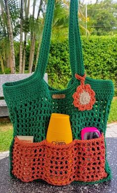 a green crocheted purse sitting on top of a table next to a cup