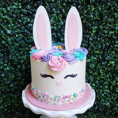 there is a cake decorated with flowers and bunny ears on top of the cake stand