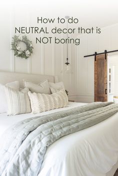 a bed with white linens and pillows on it in front of a wooden door that says how to do neutral decor that is not boring