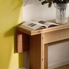 a vase filled with flowers sitting on top of a wooden table next to a book