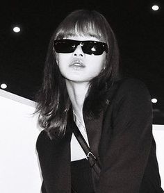 a woman wearing sunglasses and carrying a purse