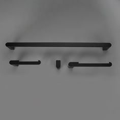 three black shelf brackets on a gray wall