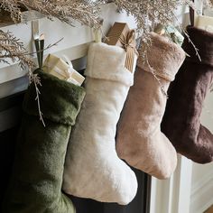 three christmas stockings hanging from a mantel