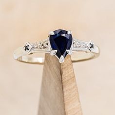 a white gold ring with a blue sapphire and diamond accents