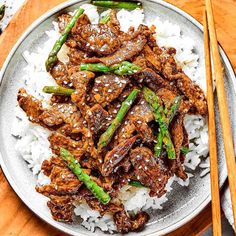 beef and asparagus served over rice in a bowl