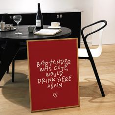 a red sign sitting on top of a wooden floor next to a table with wine bottles