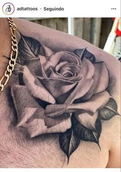 a man's chest with a rose tattoo on it