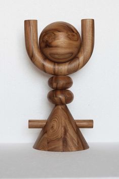 a wooden sculpture is shown against a white wall