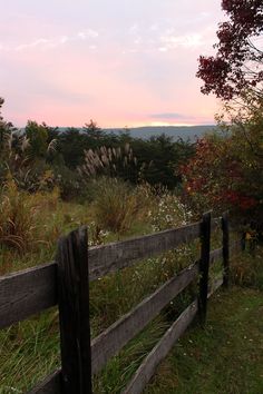 a wooden fence in the middle of a field