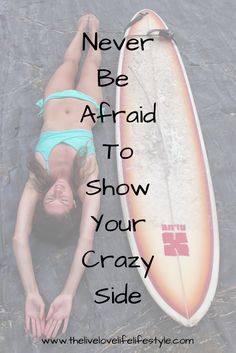 a woman laying on the ground next to a surfboard that says never be afraid to show your crazy side