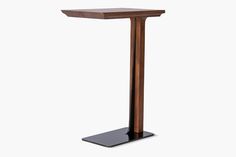 a wooden table with a metal base and a black stand on it's side