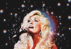 a woman singing into a microphone with stars in the background