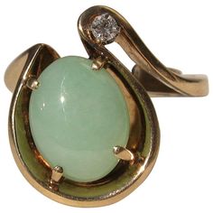 Stunning 14K gold Green Jade & Diamond Cocktail ring. center jade, measuring 14.10mm x 11.35mm x 5.0mm. Approximately 6.5 Carats. Diamond is a accent at about .5 points. Heavy free form almost horseshoe looking motif on this ring. The ring has a sizer inside of the band that allows several sizes to wear this, from a 7.5 to a 9. This is out of a massive collection of Contemporary designer & Vintage clothing as well as Hopi, Zuni, Navajo, Southwestern, sterling silver, costume jewelry, and fine je Vintage Jade Jewelry For Anniversary, Vintage Oval Jade Rings, Vintage Round Jade Rings, Vintage Jade Rings For Formal Occasions, Vintage Jade Rings For Anniversary, Mid-century Polished Finish Jewelry For Anniversary, Formal Yellow Gold Jade Ring, Silver Costume, 1st Dibs