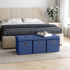 a bedroom with a bed, blue storage bins and white pillows on the floor