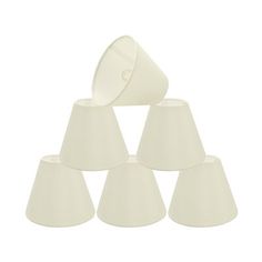 six white lampshades stacked on top of each other in the shape of pyramids