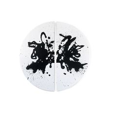 two white plates with black ink splatters on the edges, one is round