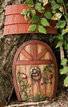 a small wooden fairy house sitting next to a tree