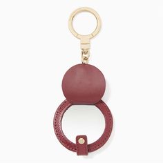 a red leather keychain with a circular ring on the front, and a gold metal