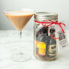 a glass filled with coffee martini next to a cocktail in a jar on a table