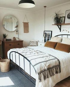 a bed room with a neatly made bed and some pictures on the wall above it