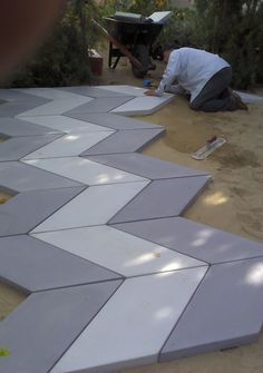 a man laying on the ground working on some tiles