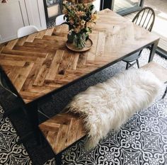 the table is made out of wood and has white fur on it, along with two chairs