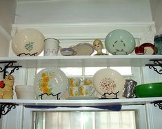 the shelves are filled with dishes and plates