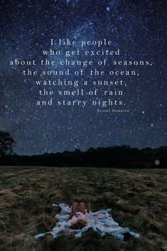 a person laying on top of a grass covered field under a night sky filled with stars