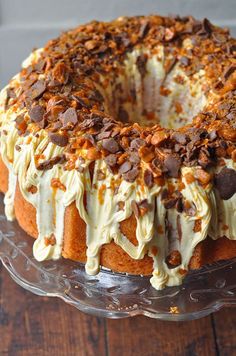 a cake sitting on top of a glass plate covered in frosting and toppings