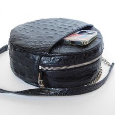 The always on-point classic black purse keeps you moving from work to play. The Classic Black Circle Purse’s updated design is a perfect blend of fashion and function with a front pocket for your cell phone and the addition of UCAN Luxury Zippers. Circle Cross-body purse Top Zipper - USA Front Cell Phone Pocket Inner Pouch Pocket Chain and Leather Strap Blue Berry Lining Black Leather - USA Approx: L 8” X H 8" X W 3" Strap: 48” Manufactured in Los Angeles, CA Pocket Chain, Circle Purse, Blue Berry, Black Circle, Iphone Prints, Black Purse, Black Purses, Crossbody Purse, Black Charcoal