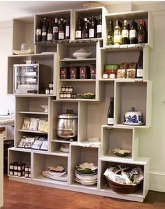 the shelves in the kitchen are filled with wine bottles