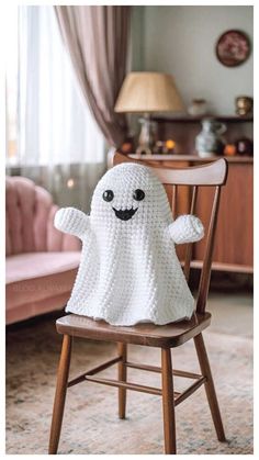 a knitted ghost sitting on top of a wooden chair