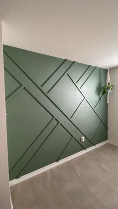 an empty room with green walls and white trim