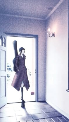 a woman standing in front of a door with a coat over her shoulders and boots on