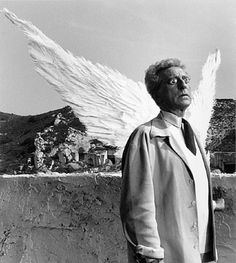 an old photo of a man with angel wings on his head and coat over his shoulders