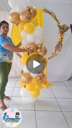 a woman standing in front of a bunch of balloons on top of a tiled floor