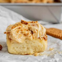 a close up of a pastry with icing and cinnamon crumbs on it