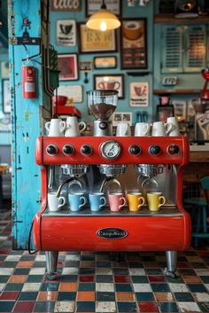 an old fashioned red coffee machine with cups on the front and sides, in a cafe