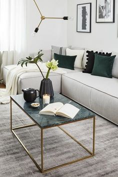 a living room with a couch, coffee table and pictures on the wall