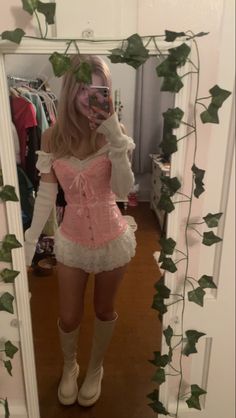 a woman in a pink corset taking a selfie