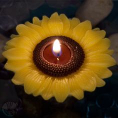 a yellow flower with a lit candle in it